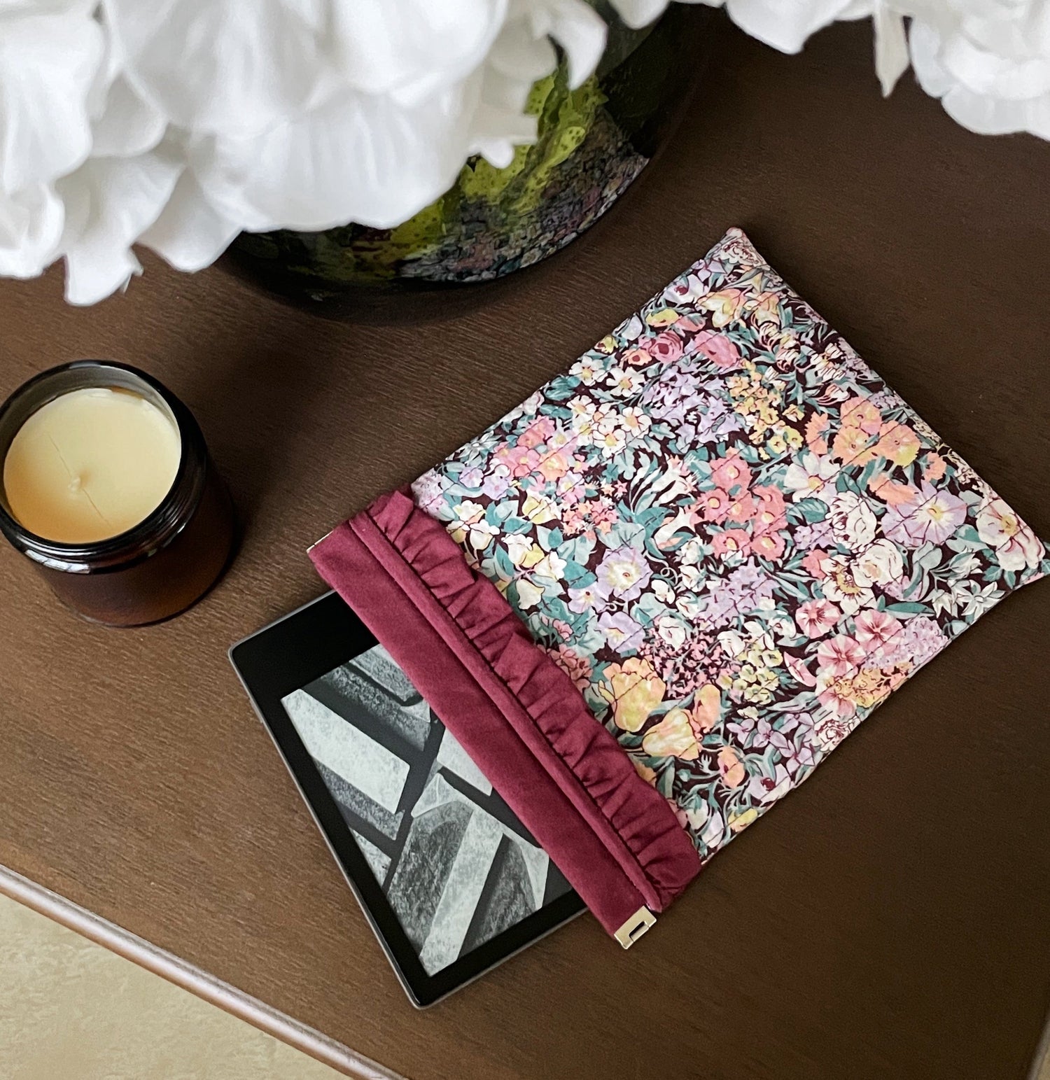 A kindle peeking out of a floral sleeve to protect it